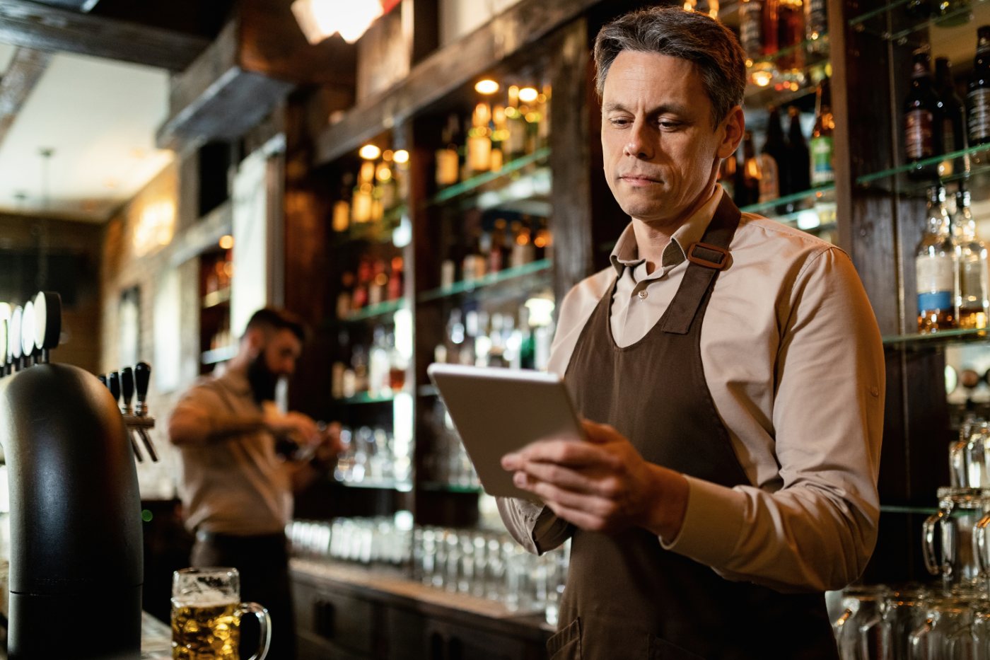 Mesero usando tablet en el bar